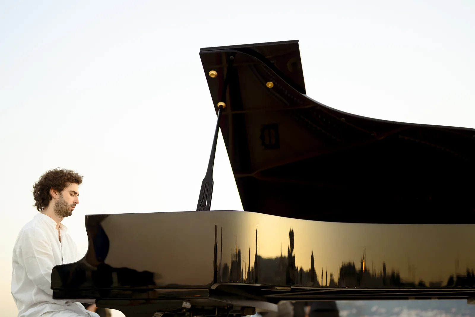 Luca Sacher al pianoforte a coda sul Molo Audace, al tramonto